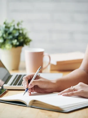unrecognizable-woman-sitting-desk-indoors-writing-planner_result servicios de traduccion